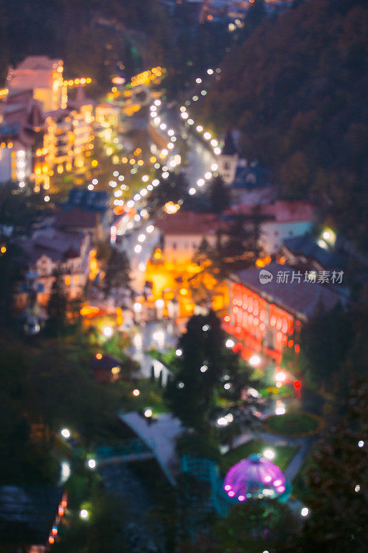 Borjomi Samtskhe-Javakheti,格鲁吉亚。抽象的虚化虚化背景傍晚Borjomi城市景观和中央公园在夜间照明照明